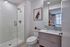 Sleek modern bathroom with a glass-enclosed shower, chic vanity, and contemporary decor.