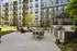 Inviting outdoor courtyard with modern grilling station, cozy fire pit seating, and elegant apartment backdrop.