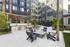 Modern apartment courtyard featuring chic outdoor seating, a stylish gas grill area, and lush greenery for a serene urban oasis.