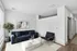 Contemporary living room with sleek dark blue sofa, modern art, and natural light. Perfect blend of style and comfort.
