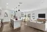 Modern open-concept apartment with a sleek kitchen island, bright dining area, and cozy living space filled with natural light from large windows.