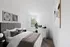 Elegant bedroom with stylish decor, featuring modern artwork and a large window allowing natural light to flood the space, complemented by a soft, neutral color palette.