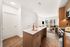 Modern open-concept kitchen and living area with sleek wooden cabinetry, stylish island, and sweeping city views through large windows.