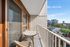 Charming balcony with cozy seating area offering breathtaking city views and modern architectural design.