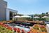 Luxurious outdoor seating area with modern tables, elegant umbrellas, and vibrant succulent landscaping, perfect for relaxation and dining.
