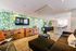 Lounge with a tropical-themed wall and modern furnishings