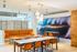 Contemporary dining and lounge area featuring modern seating, elegant tables, and stunning wave art