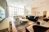 Elegant and spacious lounge area with modern seating, stylish decor, and abundant natural light streaming through large windows, perfect for relaxation or social gatherings