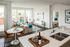 Modern living space featuring a cozy living area, dining set, and contemporary kitchen with sleek countertops