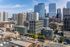 Vibrant city skyline featuring modern high-rise buildings and tree-lined streets, showcasing urban living at its finest.