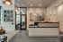 Modern office reception area with a stylish desk, abstract artwork, and elegant pendant lighting, creating a welcoming atmosphere.