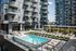 Modern apartment complex featuring a luxurious outdoor pool area with stylish lounge chairs and shaded seating, ideal for relaxation and social gatherings.