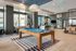 Elegant and modern recreational space with a sleek pool table, inviting seating area, and stylish barstools in a bright, open-layout apartment community room.