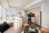 Modern apartment with an open-concept kitchen boasting sleek appliances and a bright living area with panoramic city views.