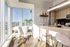 Bright, modern apartment kitchen with sleek surfaces, stylish breakfast bar, and stunning city views.