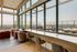 Elegant penthouse lounge with panoramic city views, featuring plush seating and floor-to-ceiling windows.