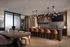 Luxurious open-plan kitchen and dining area with sleek marble countertops, contemporary light fixtures, and elegant seating, perfect for entertaining.