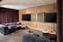 Luxurious modern lounge area featuring plush gray seating, elegant marble coffee tables, and multiple large screens, perfect for relaxation and entertainment.