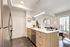 Modern apartment kitchen with sleek wooden cabinetry, stainless steel appliances, and a stylish open-plan living area with bright city views.