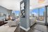 Modern apartment living room with elegant decor, panoramic city views from large windows, and a sleek open kitchen design.