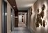 Elegant hallway in a luxury apartment building featuring modern elevators and artistic wall lighting.