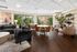 Chic communal lounge with contemporary decor, featuring cozy sofas, elegant dining tables, and lush greenery against floor-to-ceiling windows.