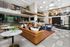 Sophisticated apartment lobby featuring chic leather and velvet seating, sleek marble tables, and modern lighting in an open, airy layout.