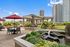 Luxurious rooftop patio with vibrant flowers, elegant pergola, and city skyline views.