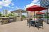 Chic urban patio with elegant pergolas, modern outdoor seating, and lush greenery offering a stunning cityscape view.