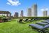 Luxurious rooftop garden with elegant loungers, lush greenery, vibrant flowers, and captivating cityscape views.