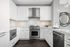 Elegant modern kitchen featuring sleek white cabinetry, marble countertops, and stainless steel appliances with stylish pendant lighting.