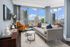 Bright, modern living room with floor-to-ceiling windows, showcasing stunning city views and elegant decor.