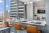 Modern kitchen with sleek countertops, stylish pendant lighting, and a stunning city view, perfect for urban living.