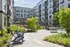 Chic apartment courtyard with lush greenery, modern outdoor seating, and vibrant communal spaces.