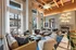 Luxurious modern living room with high ceilings, elegant furniture, and large windows offering urban views.