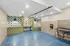 Modern pet wash station with vibrant blue and green tiles, featuring washing areas and sleek overhead lighting.