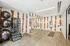 Modern fitness room with vibrant orange accents, mirrored wall, and diverse workout equipment including exercise balls and resistance bands.