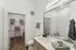 Elegant bathroom with a sleek vanity, large mirror, and a modern glass shower, offering a luxurious and serene atmosphere.