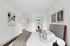 Modern bedroom with elegant decor, showcasing plush bedding, minimalist artwork, and a spacious walk-in closet.