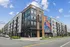 Modern urban apartment complex featuring sleek architecture with colorful mural artwork and large windows, ideal for contemporary living.