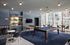 Elegant game room with modern pool table, stylish seating, and large windows offering city views.