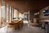 Luxurious open-concept living space featuring elegant wooden dining table, modern chairs, and cozy lounge seating with floor-to-ceiling windows.