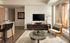 Modern living room with sleek furniture, a stylish glass coffee table, and floor-to-ceiling windows opening to a balcony.