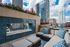 Luxurious urban terrace featuring stylish outdoor seating, vibrant flowers, and panoramic city skyline views.