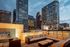 Luxurious rooftop patio with cozy seating and modern fireplace offering stunning cityscape views at dusk.