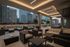 Chic outdoor terrace with modern seating, ambient lighting, and a vibrant cityscape backdrop, perfect for relaxation and gatherings.