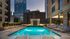 Luxurious rooftop pool with elegant lighting and city skyline views, perfect for relaxation and enjoyment.