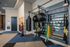 Modern fitness center with versatile workout equipment, including hanging punching bag, exercise balls, and kettlebells, offering a dynamic and inspiring workout space.