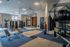 Spacious and modern apartment gym with state-of-the-art fitness equipment, vibrant floor tiles, and ample natural light.