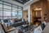 Chic urban living room with modern furnishings, floor-to-ceiling windows, and inviting outdoor terrace view.